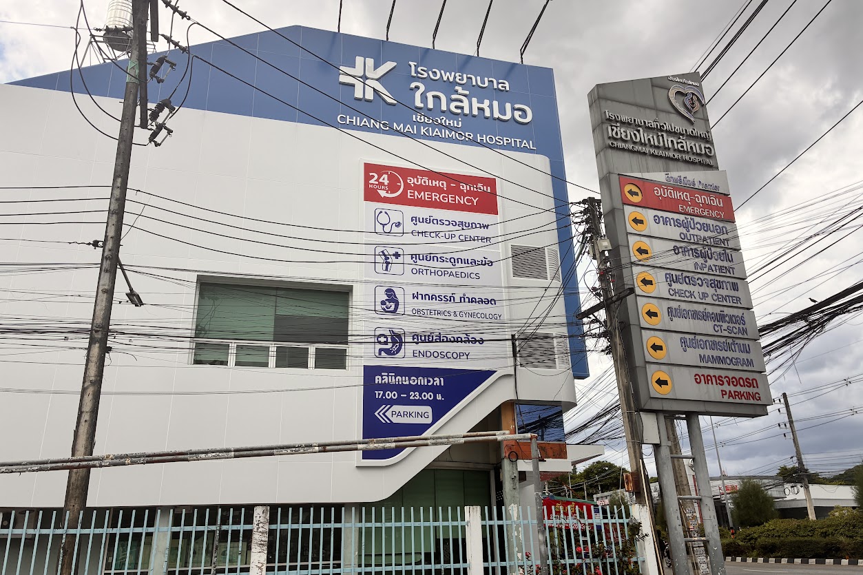 Bilingual signage at a Chiang Mai private hospital listing emergency, CT scan and mammogram services
